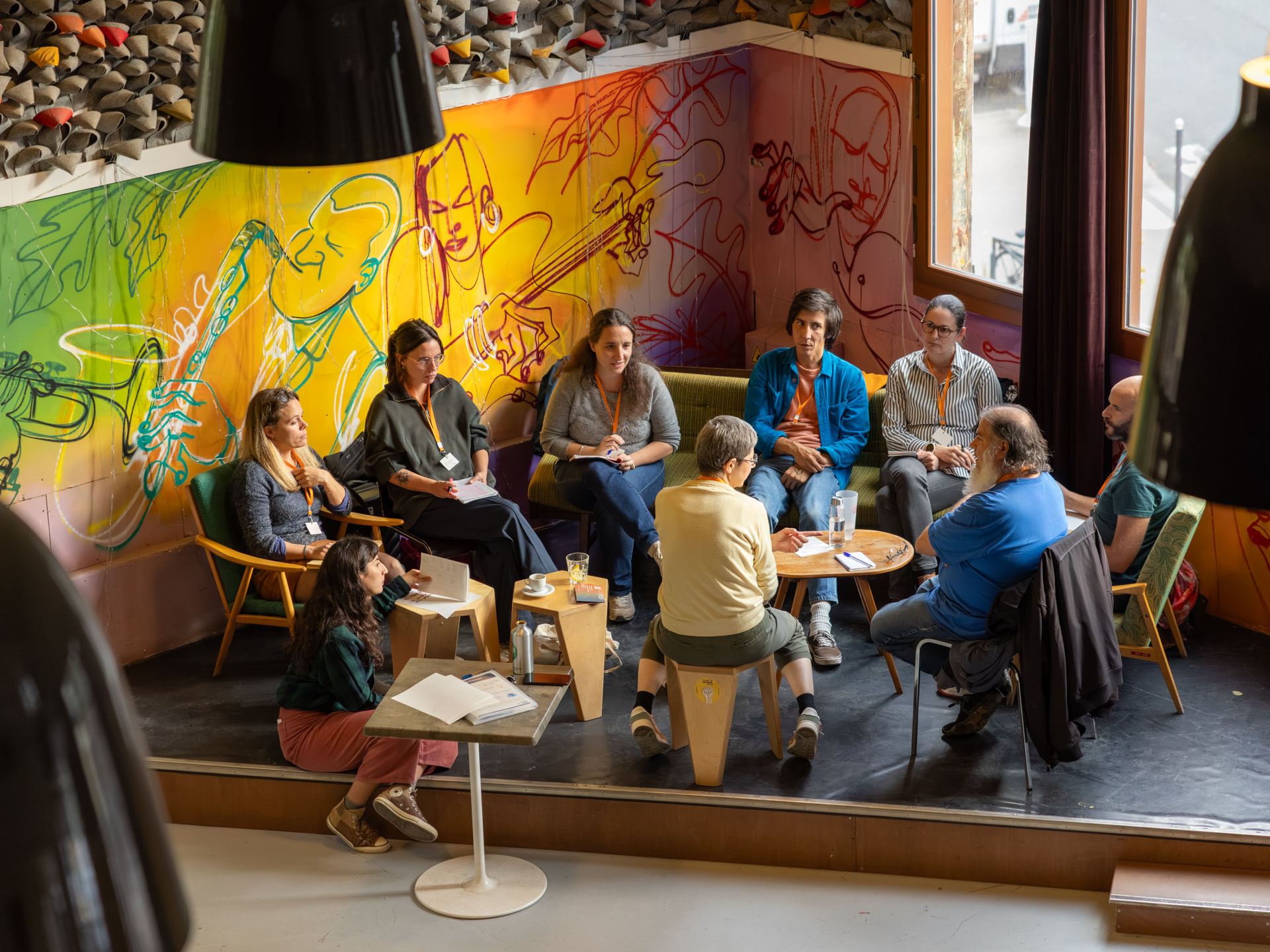 Groupe de freelances qui discutent ensemble dans une ambiance décontracté assis sur des chaises et un canapé